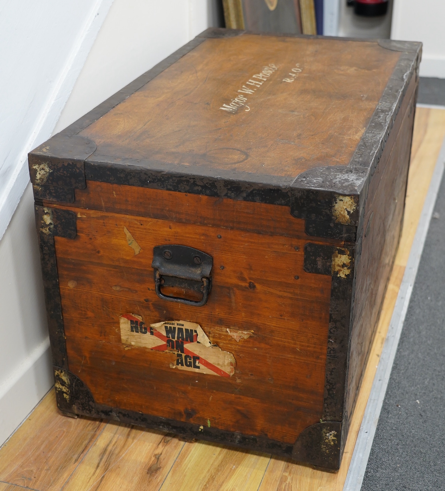 A pine military trunk with steel banding to all edges and corners, and original tin lining, owner’s name painted to the lid; ‘Major W.H. Postle R.A.O.C.’, 91.5cm wide, 54cm deep, 53cm high. Condition - fair to good
